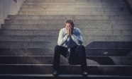businessman crying lost in depression sitting on street concrete stairs